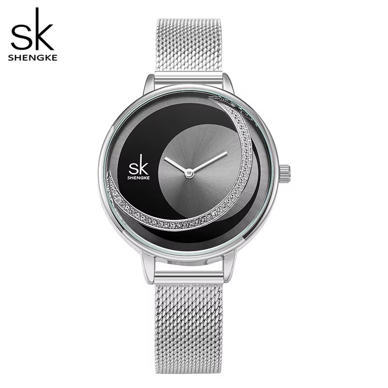 Montre femme SHENGKE, cadran noir orné d'un croissant de pierres scintillantes, boîtier argenté, bracelet maille argentée