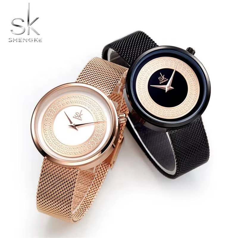 Deux montres femme SHENGKE au cadran ciselé, version ton or rose sur maille ton or rose et version noire sur maille noire